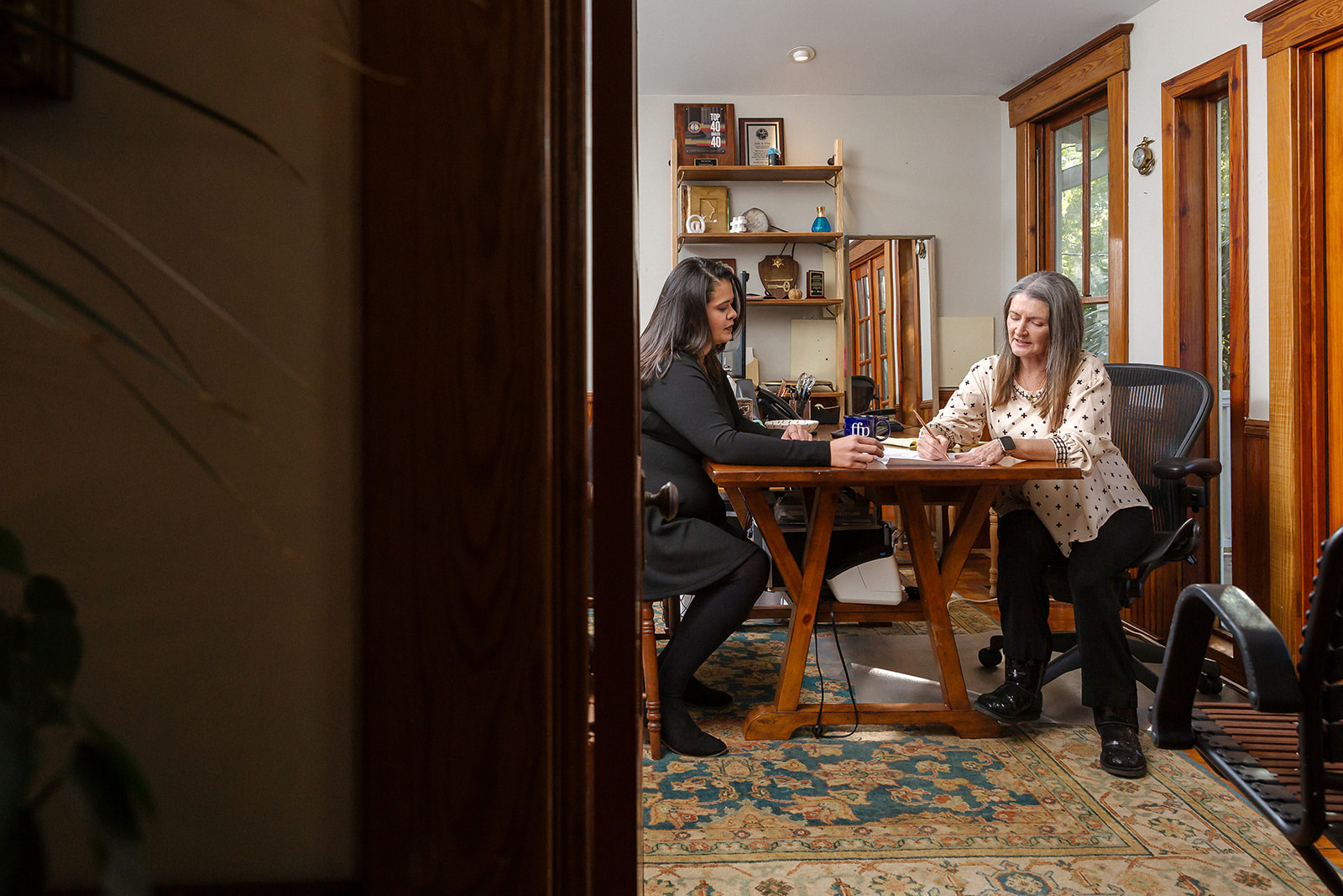 Cherie Fine signs paperwork with a client.